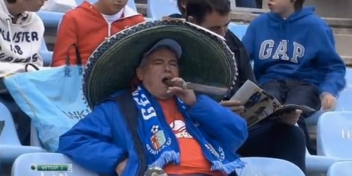 A fan enjoys a football game with a huge cigar!!